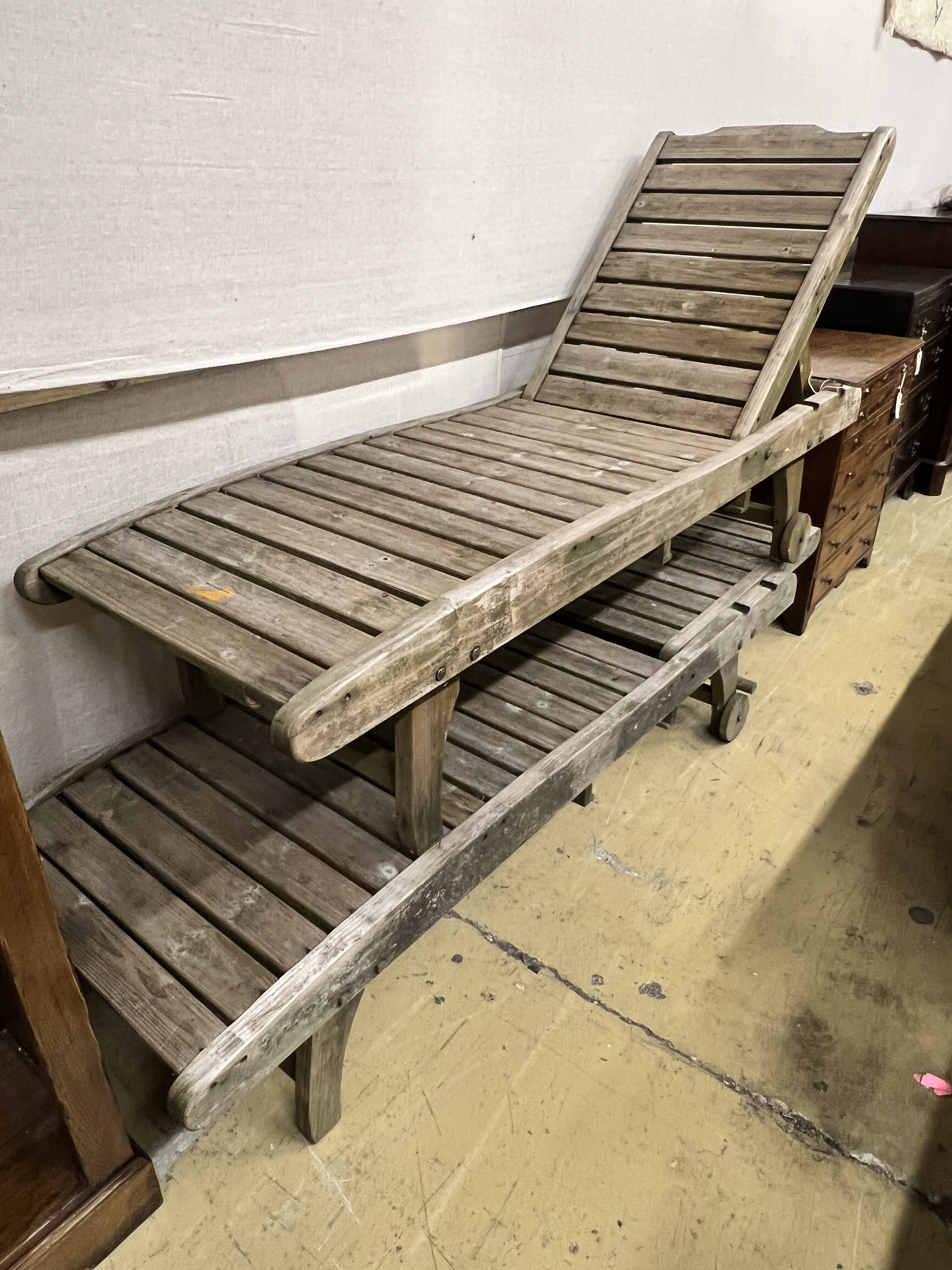 A pair of weathered teak garden loungers, length 180cm, width 58cm